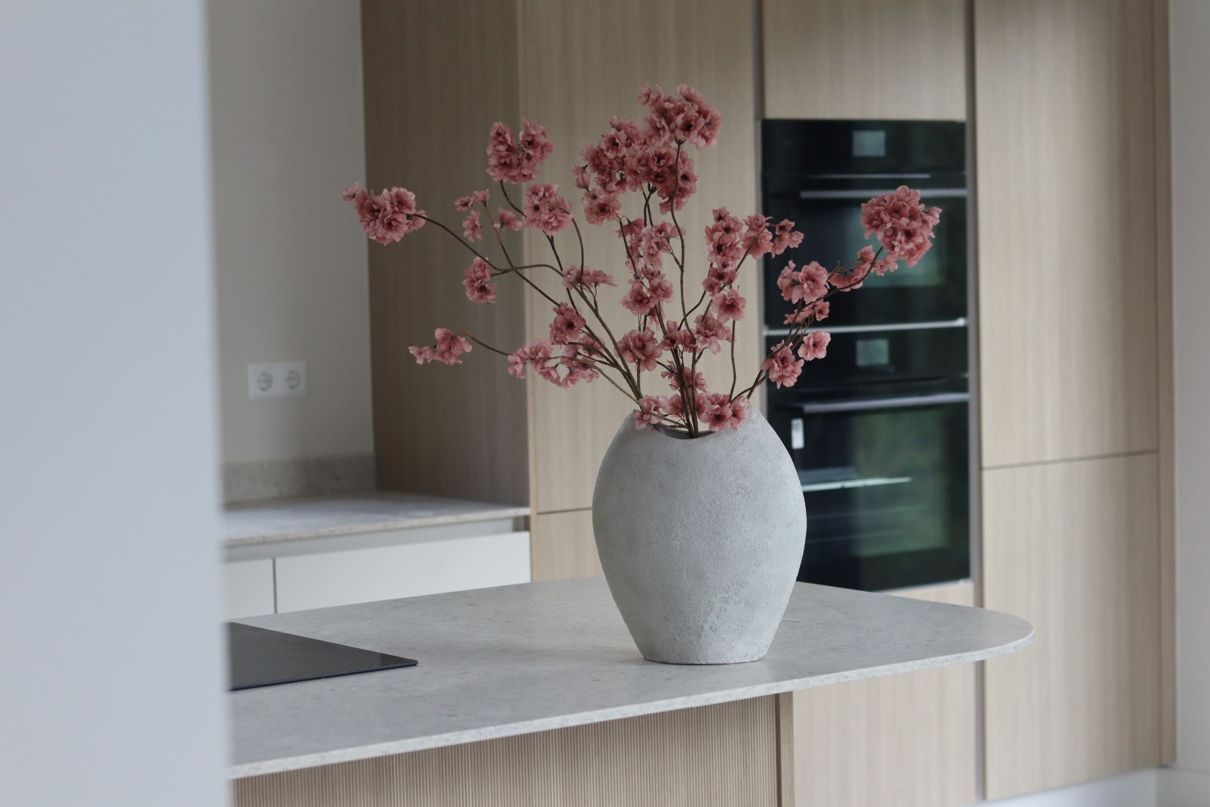 Bloesemboeket in een vaas bij een lichte keuken